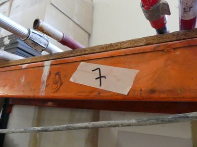 a red fire hydrant sitting on top of a wooden shelf