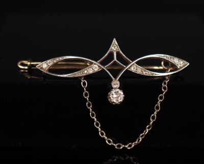 une broche en or et diamants avec une chaîne