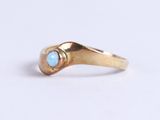 a close up of a gold ring with a turquoise stone