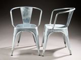 pair of silver metal chairs against a gray background