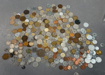 a pile of coins on the floor next to a bottle of water