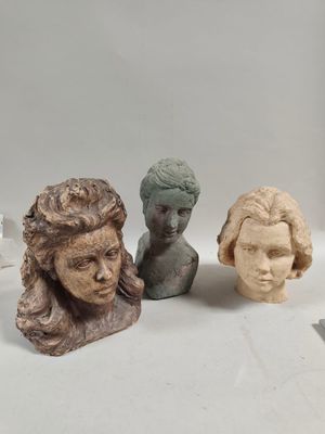 three clay sculptures of a woman ' s head and a man ' s head