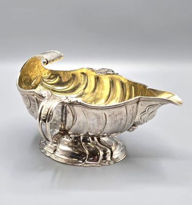 an image of a silver and gold fish shaped dish on a stand