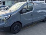a grey van parked in front of a building in a parking lot