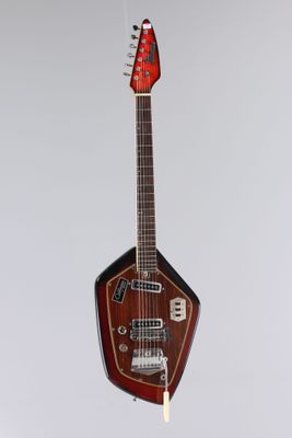 une guitare suspendue à une ficelle sur un mur blanc