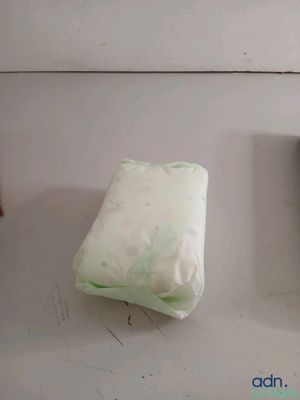 two bags of food sitting on a counter next to a bottle of water