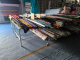 many rolls of fabric sitting on a table in a room