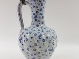 a blue and white vase with a handle on a stand