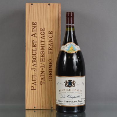 the bottle of wine is sitting next to a wooden box