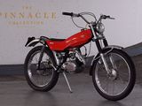 a red motorcycle parked in front of the pinnacle collection sign
