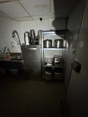 une cuisine avec beaucoup de casseroles et de poêles sur les étagères