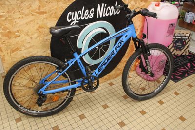a bicycle that is parked next to a sign that says cycles nica