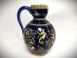 a blue vase with a gold decoration on it
