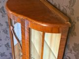 a corner cabinet with a glass door in the corner of the room