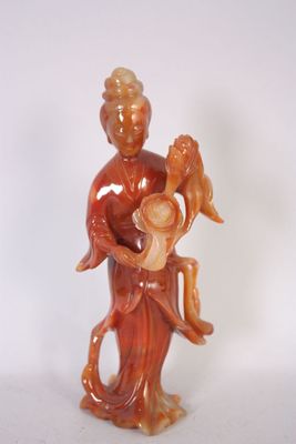 une figurine représentant une femme tenant un bébé et un oiseau