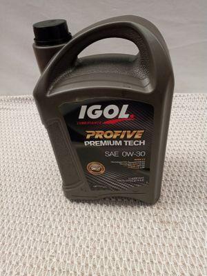 a close up of a bottle of engine oil on a table
