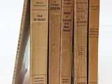 plusieurs vieux livres sont empilés sur une surface blanche