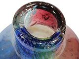 a colorful glass vase sitting on top of a table