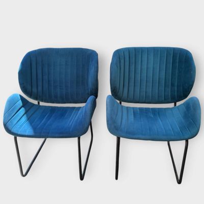 pair of blue velvet chairs with black metal legs