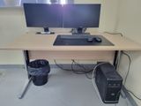 a computer desk with two monitors and a keyboard on it