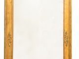 un miroir encadré d'or sur un mur blanc avec un fond blanc