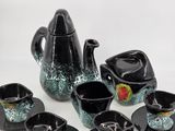 a black and green tea set with cups and saucers