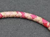 a snake that is laying on the ground with it ' s head in the middle of the rope