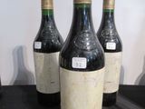 Quatre bouteilles de vin sont alignées sur une table noire