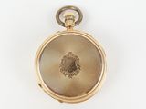 a gold pocket watch on a white surface
