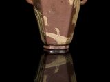a brown vase with a red lid on a black surface