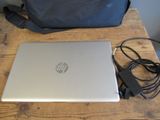a laptop computer sitting on a wooden table with a handbag
