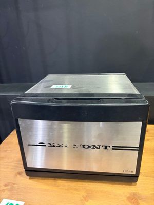 a silver and black oven sitting on top of a wooden table