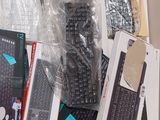 many different types of keyboards and remotes sitting on a table