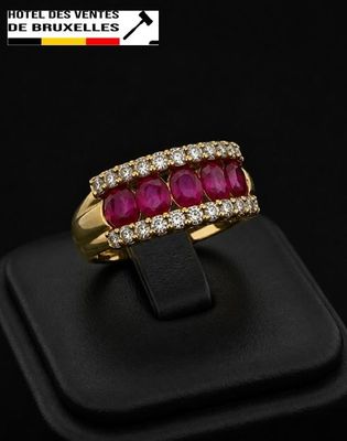 a close up of a gold ring with a ruby and diamond band
