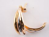 a close up of a gold plated brooch with a curved design