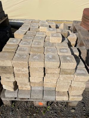 un tas de briques posé sur une palette à côté d'un camion