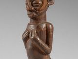 une figurine en bois représentant un homme avec un chapeau sur la tête