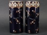pair of black and gold vases with floral designs on them