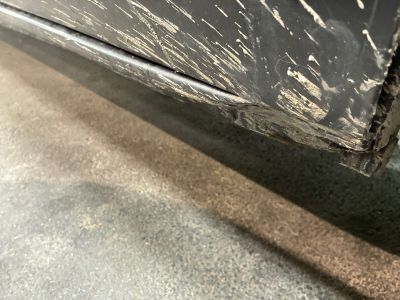 un gros plan d'une voiture noire présentant des traces de peinture blanche