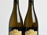two bottles of wine sitting on top of a wooden table next to each other