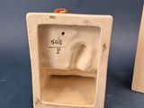 two ceramic figurines of a cat and a dog in a box