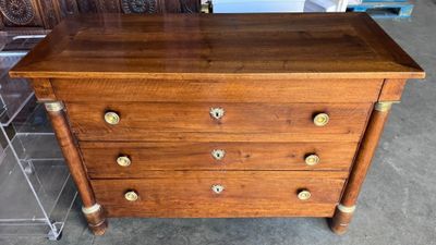 une commode en bois posée sur un sol carrelé