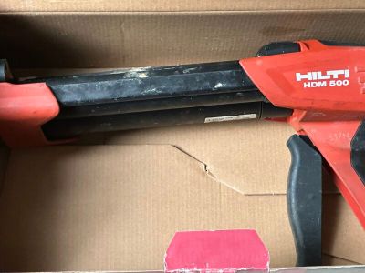 un pistolet à colle électrique rouge et noir dans une boîte en carton
