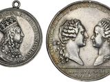 two silver medals of two women with crowns on them