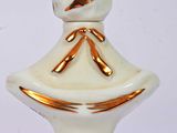 a small white vase with a gold ribbon on it