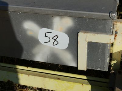 a metal box with a sticker on it sitting in the grass