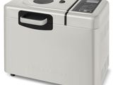 une machine à pain argentée et noire posée sur un plan de travail blanc