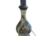 une lampe sur laquelle est posé un vase bleu et blanc