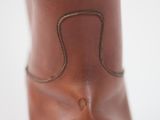 a close up view of a brown boot with a small hole in the sole