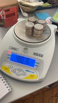 une pile de pièces posée sur une balance, elle-même posée sur une table